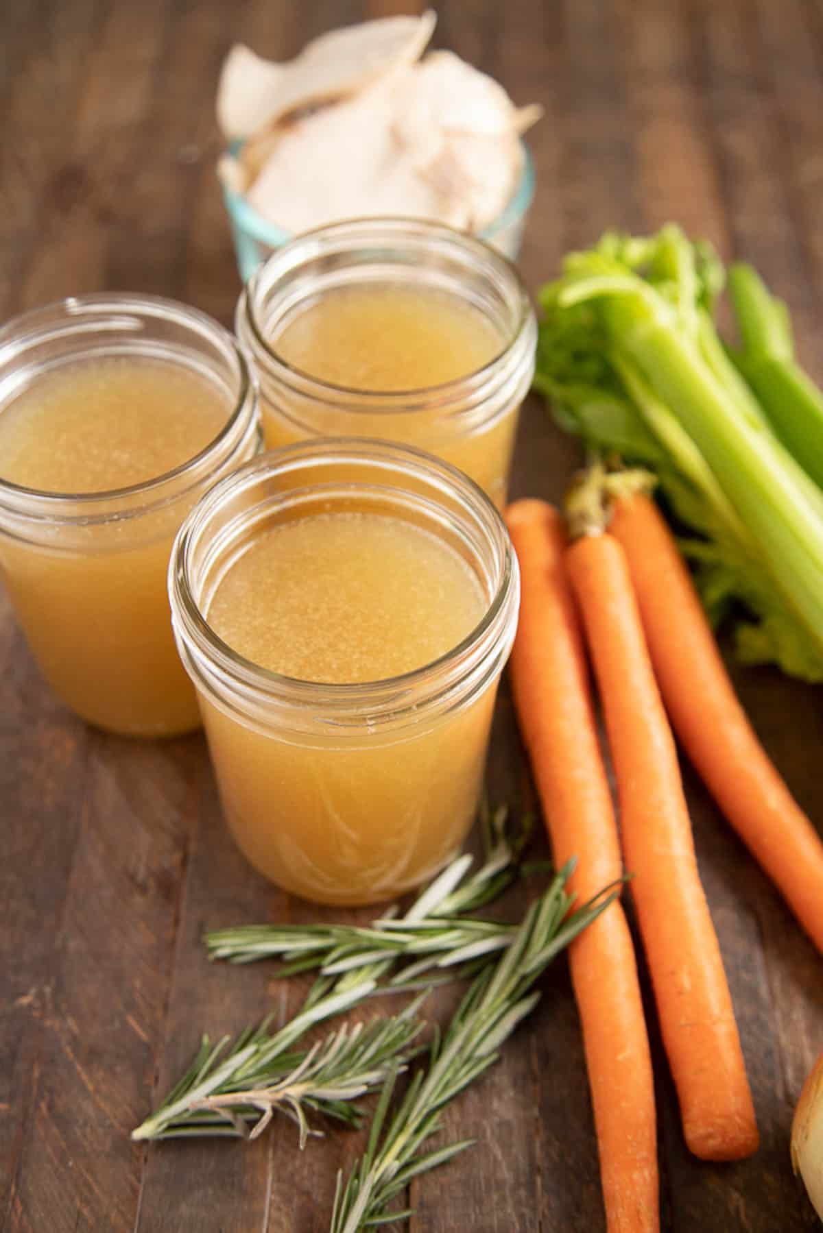 chicken stock in 3 mason jars with vegetables