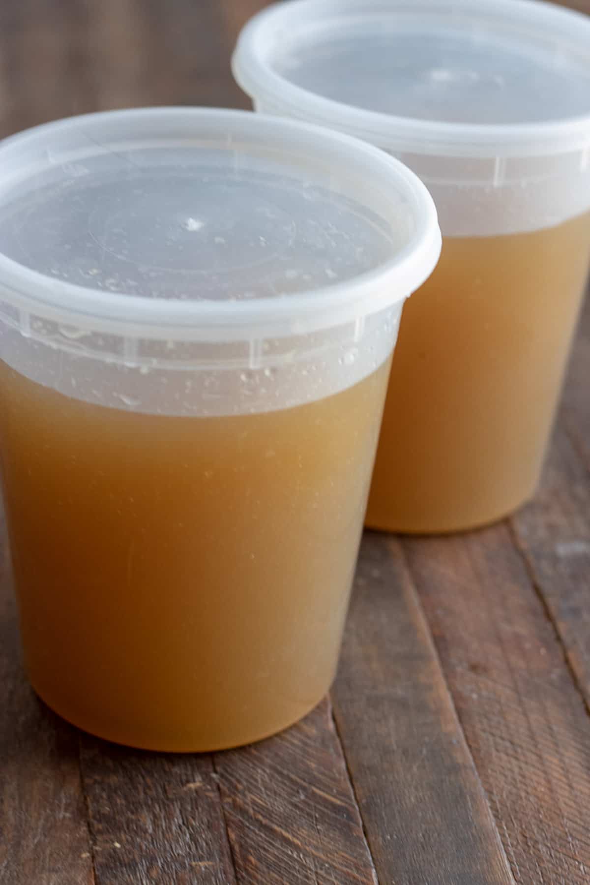 plastic containers with chicken stock ready for the freezer