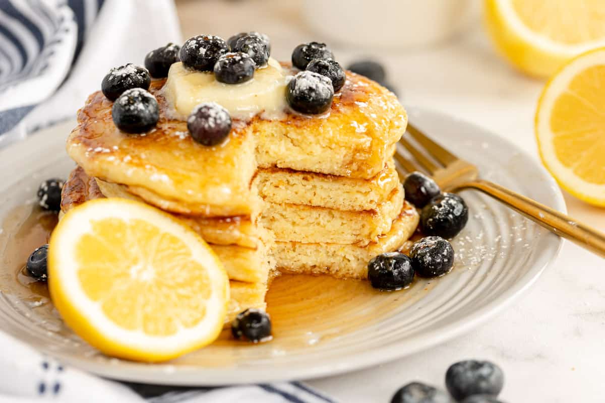 stack of pancakes with a cut lemon, ricotta and blueberries.