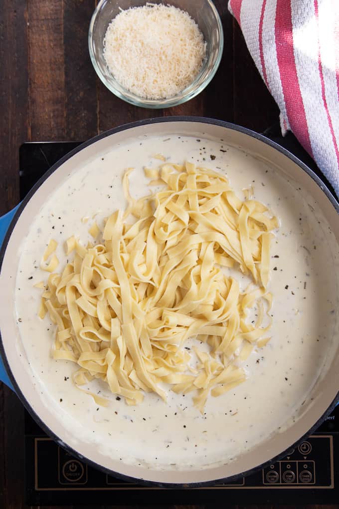 skillet with creamy sauce and fettuccine pasta.