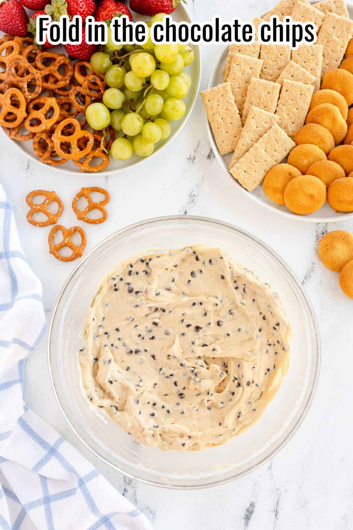 Mixed cookie dough dip with chocolate chips in a glass bowl.