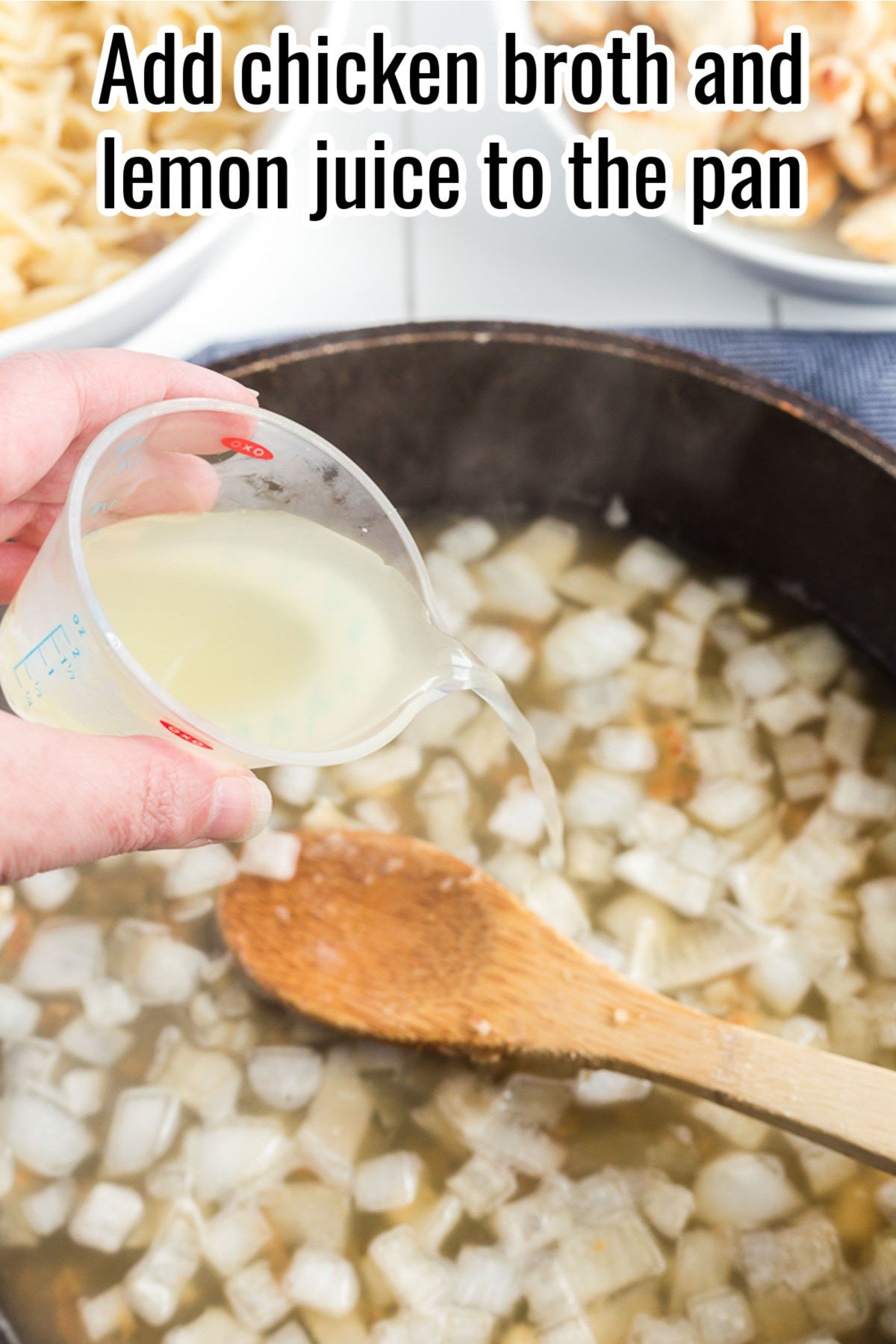 a hand adding lemon juice to a skillet with liquid and onions.