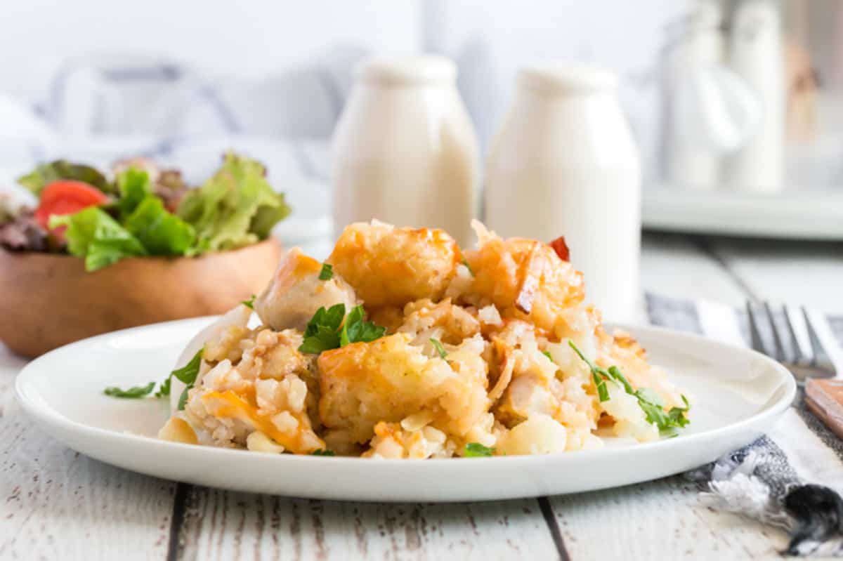 tater tot casserole with salad and white salt and pepper shakers.