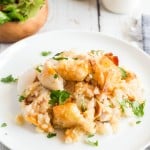 chicken tater tot casserole on a white plate with parsley.