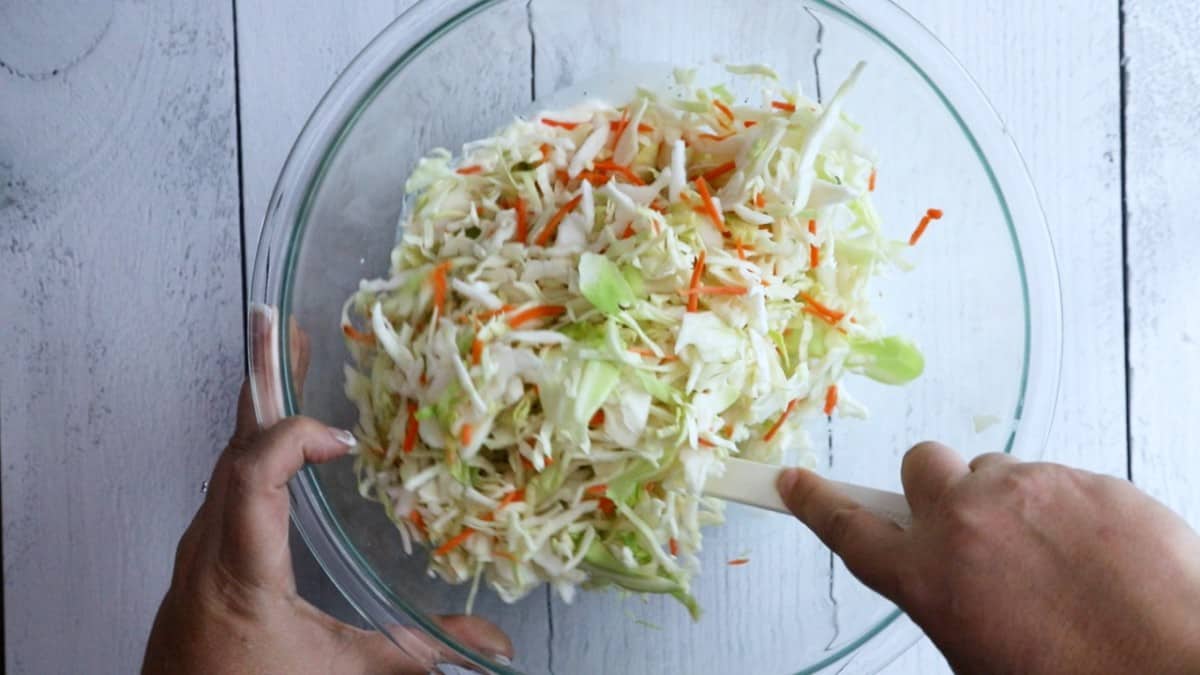 coleslaw mix added to a glass bowl.