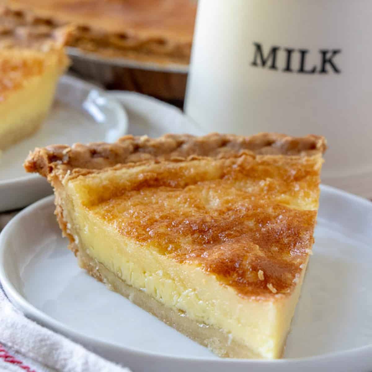 Buttermilk pie on a plate with a milk jug
