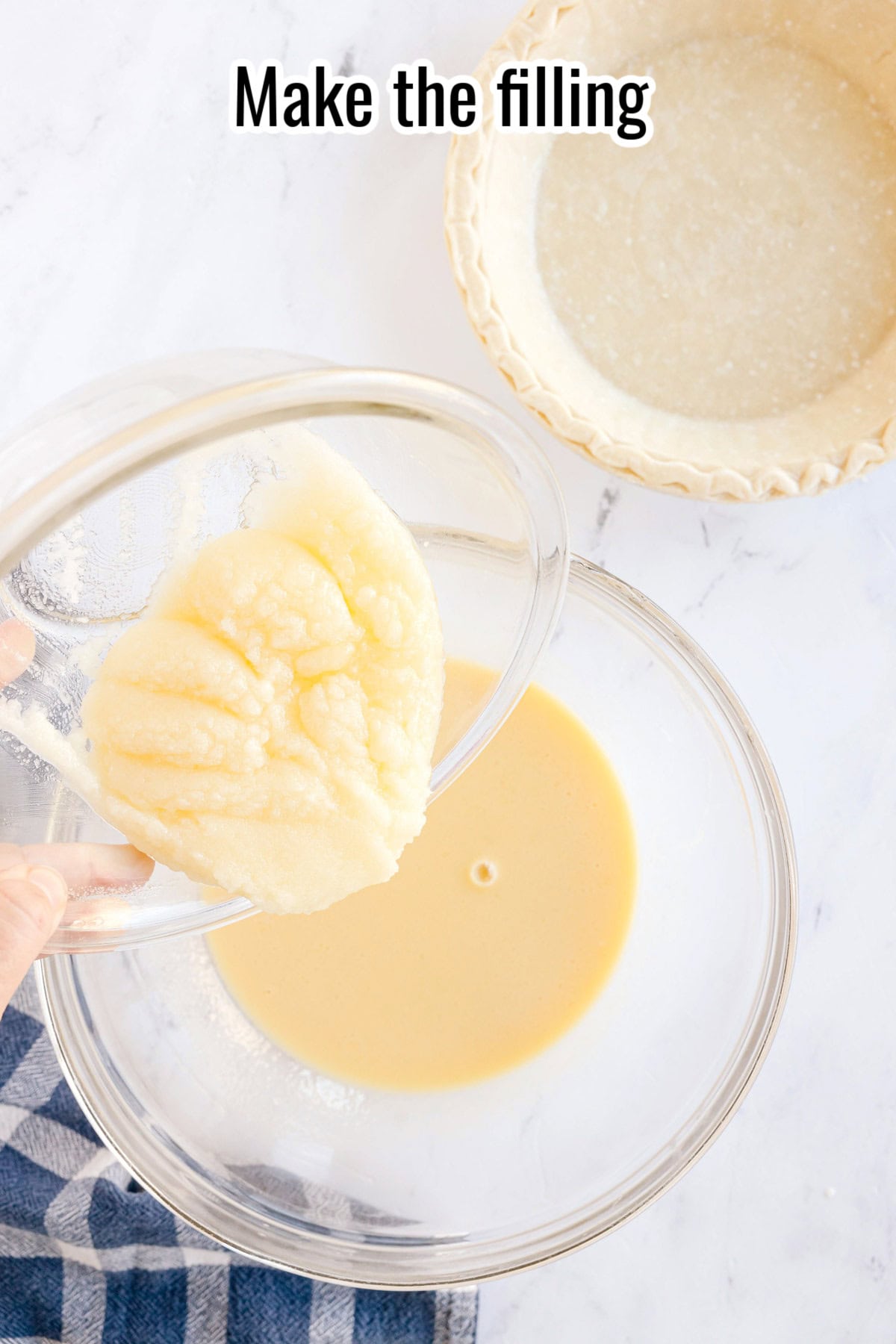 A hand pours thick buttermilk pie filling from a glass bowl into another bowl containing liquid batter, with an empty pie crust nearby; text above reads “Make the filling.”