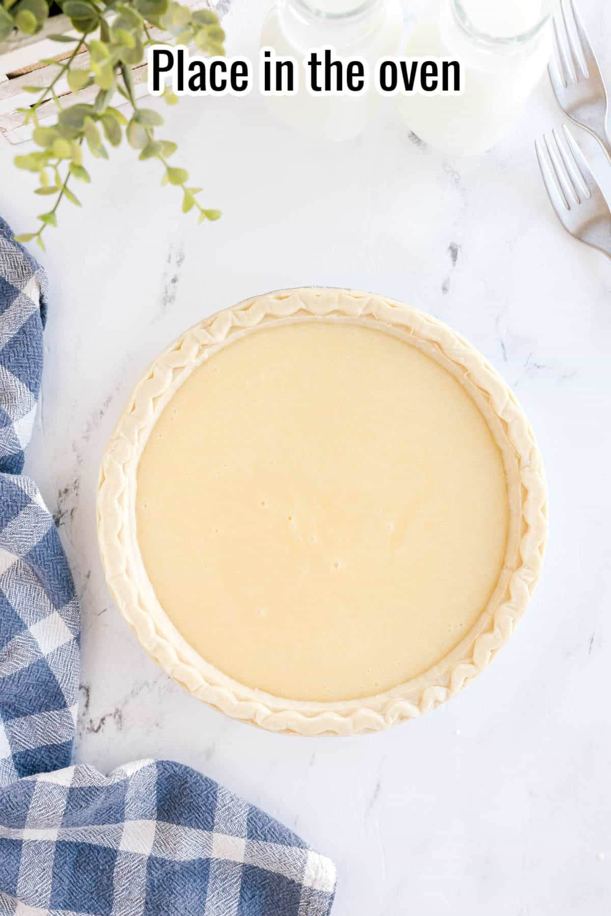 An unbaked buttermilk pie in a crimped crust on a white marble surface, with the text “Place in the oven” overlaid.
