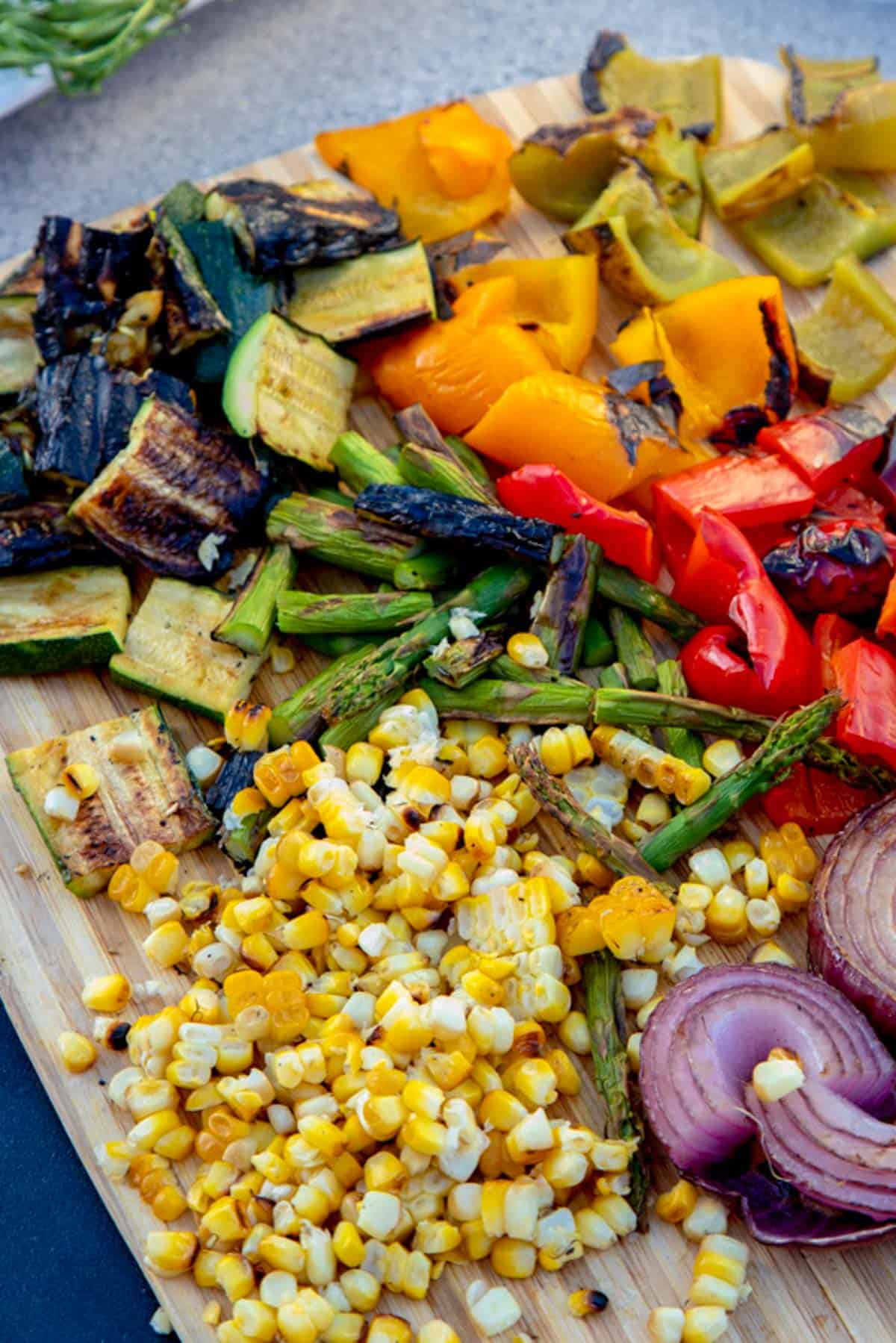 chopped grilled vegetables on a chopping board.