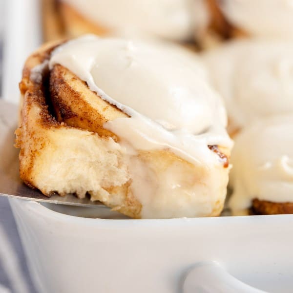 a cinnamon roll in a white baking dish.