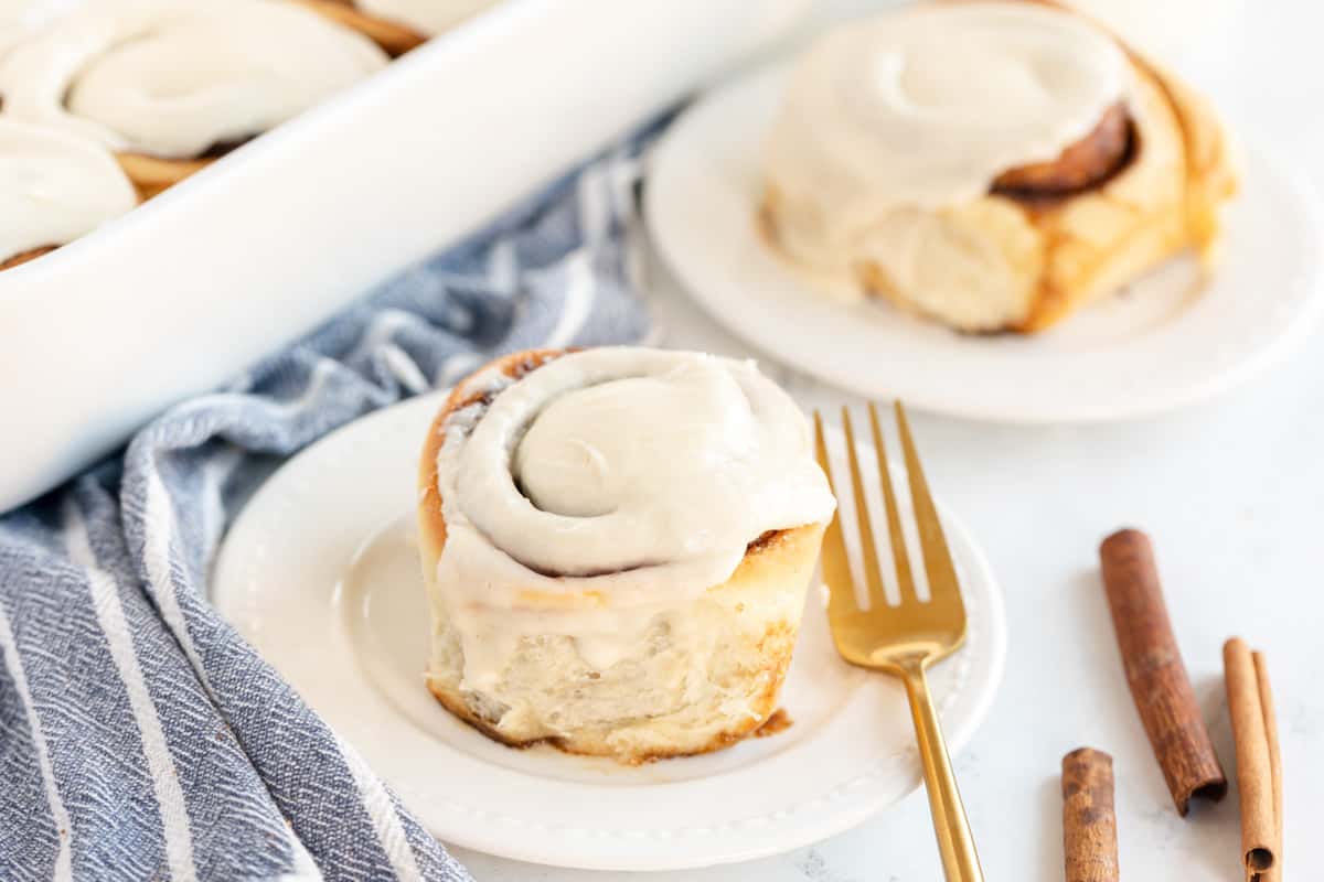 a cinnamon roll on a plate with a fork.