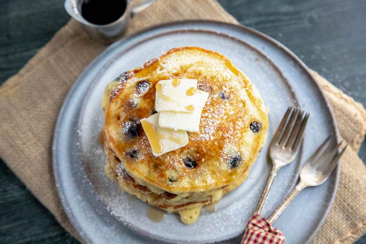 top down shot of blueberry pancakes on a grey plate