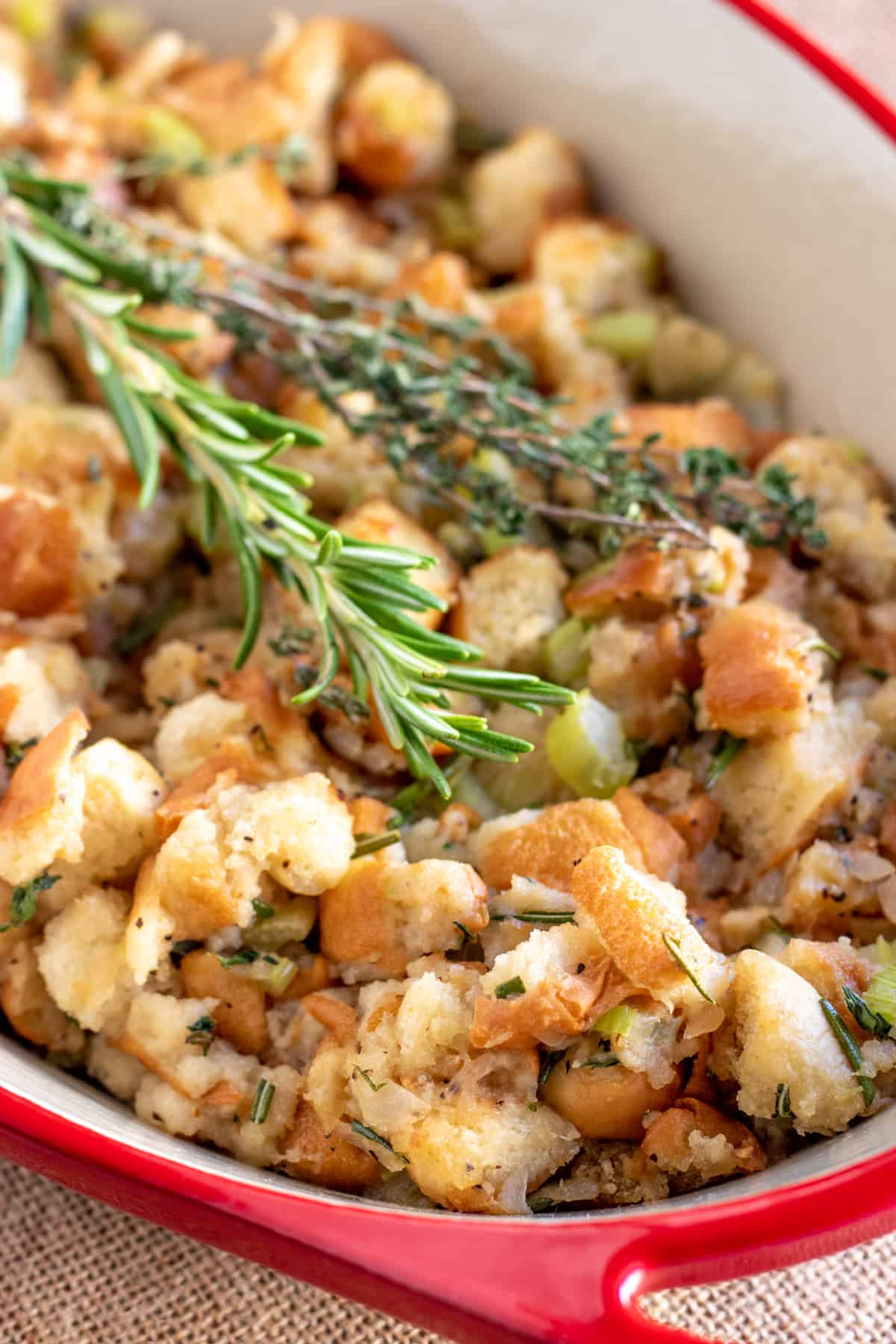 easy homemade stuffing in a red casserole dish with fresh herbs