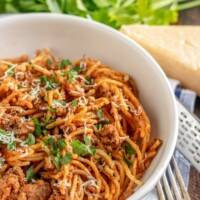 instant pot spaghetti in a white bowl with parsley and parmesan