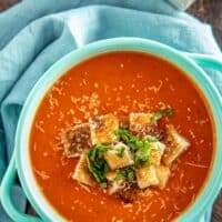 tomato soup in an aqua bowl with croutons