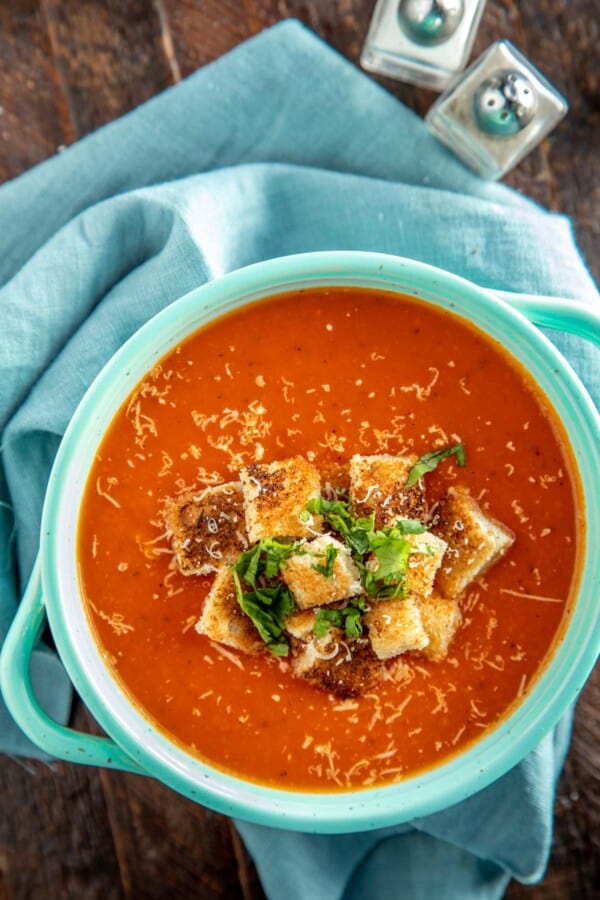 tomato soup in an aqua bowl with croutons