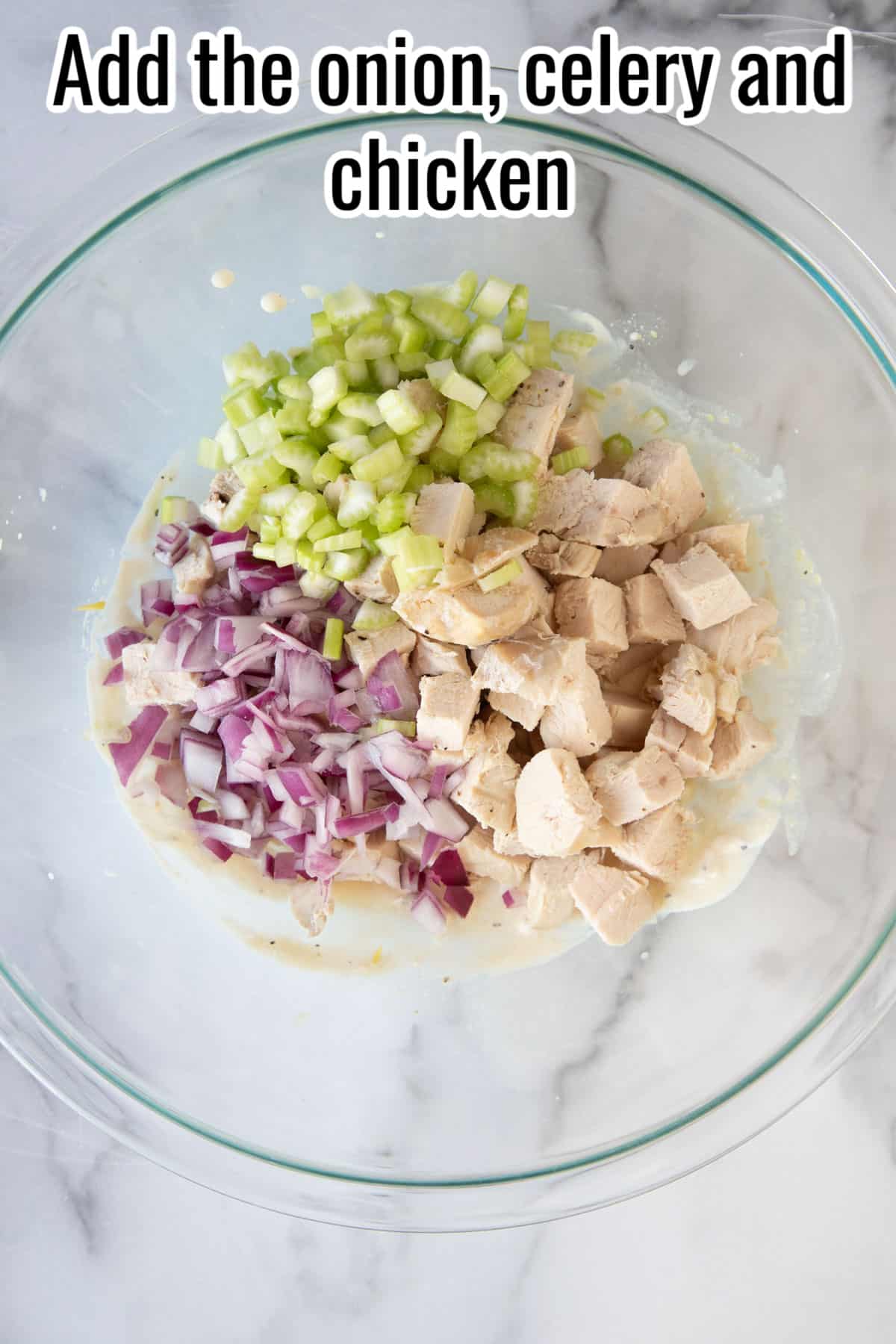 a glass bowl with celery, onion and chicken.
