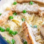 chicken alfredo pasta with peas in a blue skillet