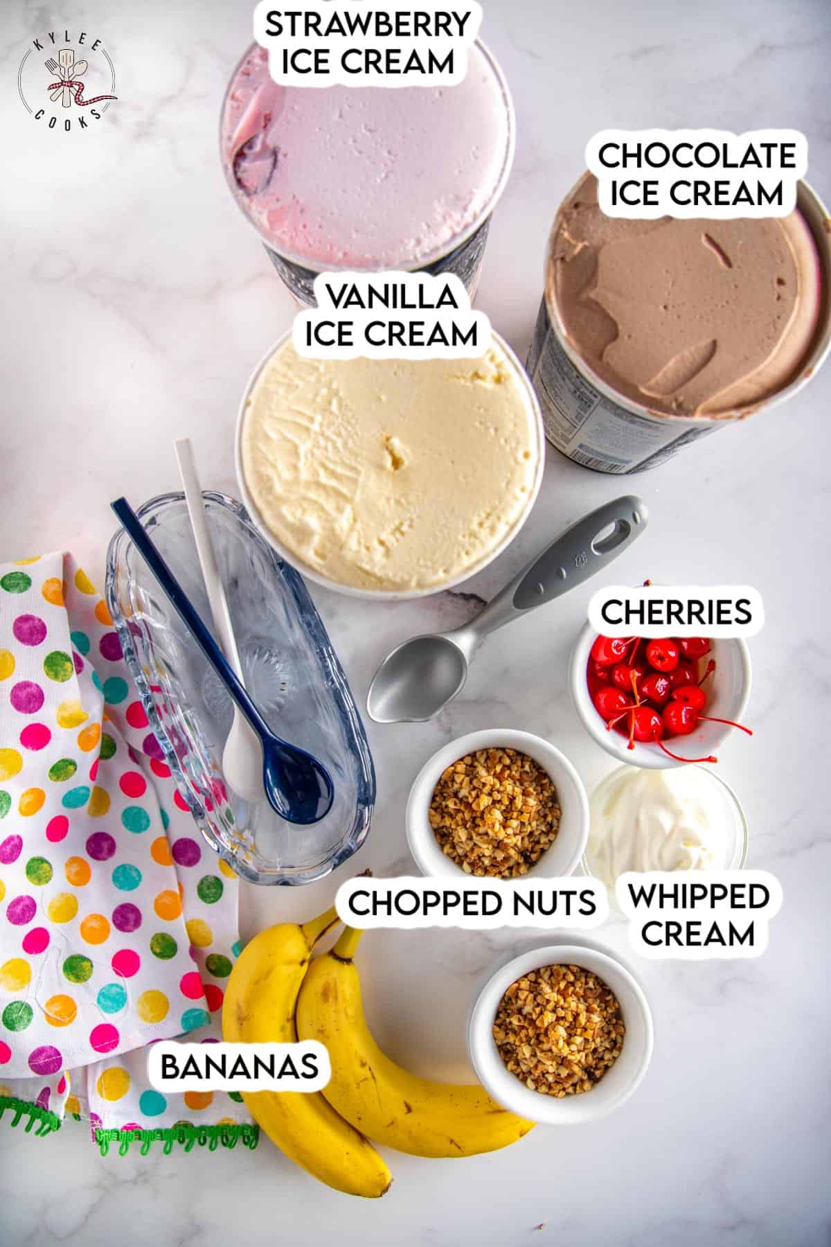ingredients to make a banana split laid out and labeled.