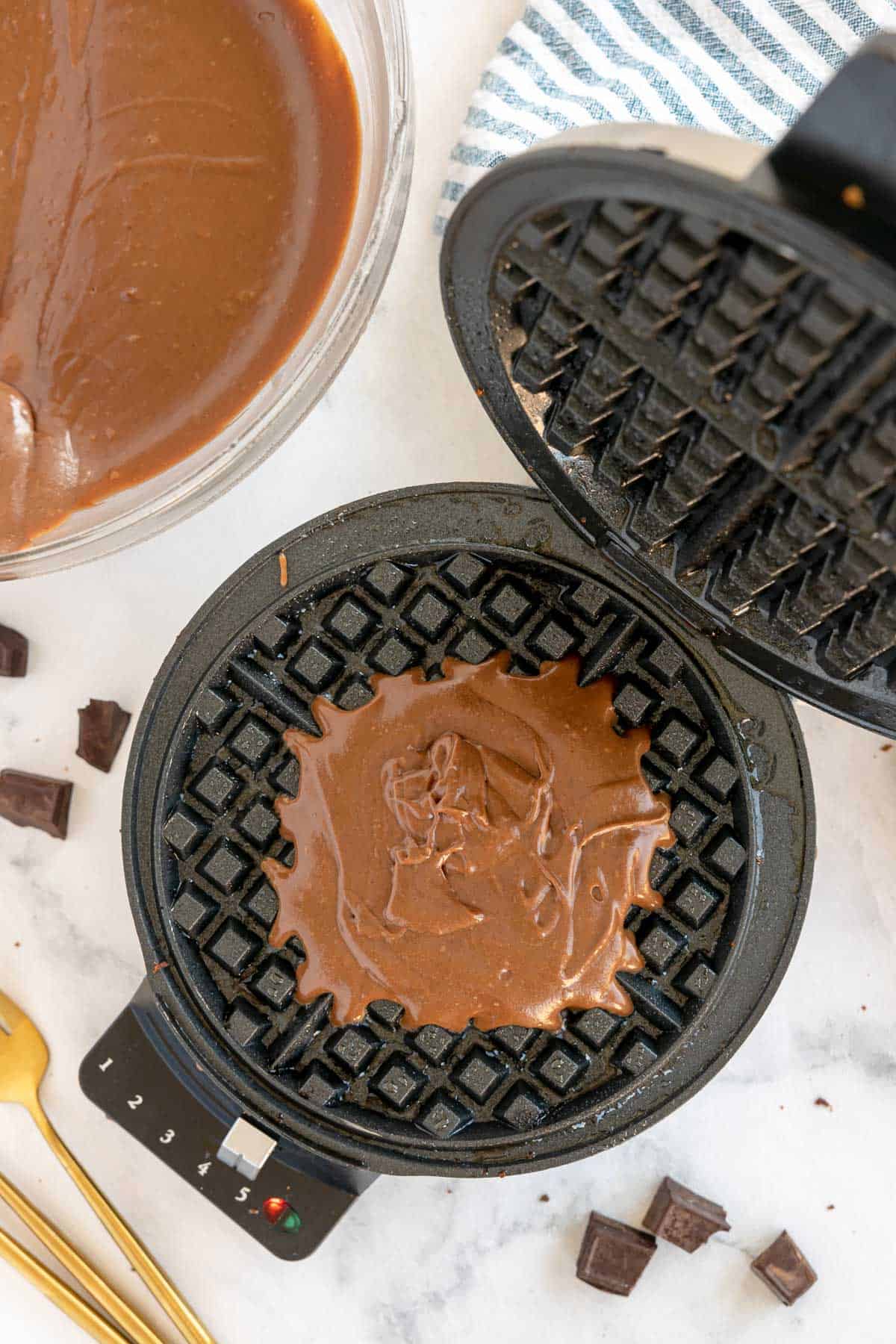 waffle iron with brown batter in it.