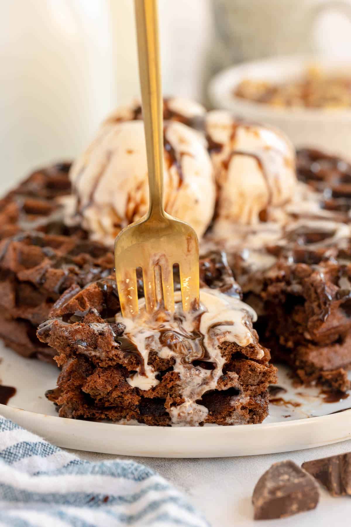 brownie waffles on a plate with a gold fork.