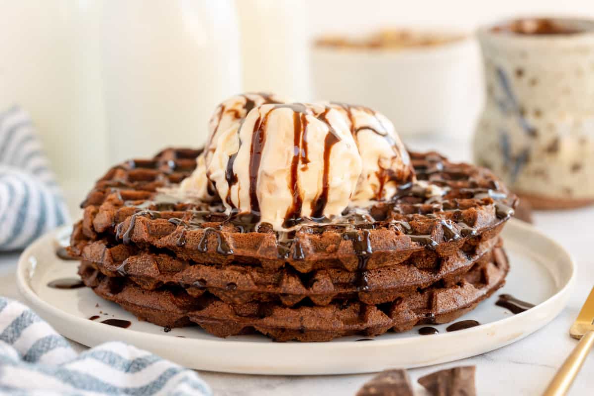 brownie waffles on a plate with a scoop of vanilla icecream.