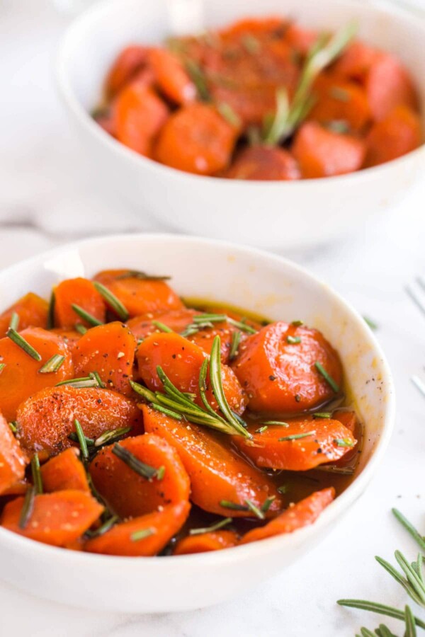 carrots with rosemary in two white bowls
