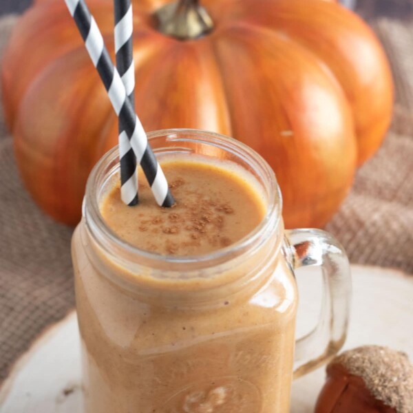pumpkin smoothie in a mason glass with black and white straws