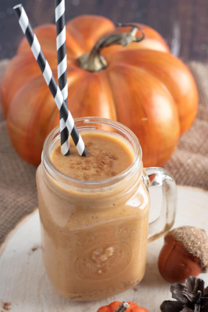 pumpkin smoothie in a mason glass with black and white straws