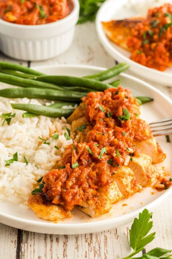 chicken romesco on a plate with green beans