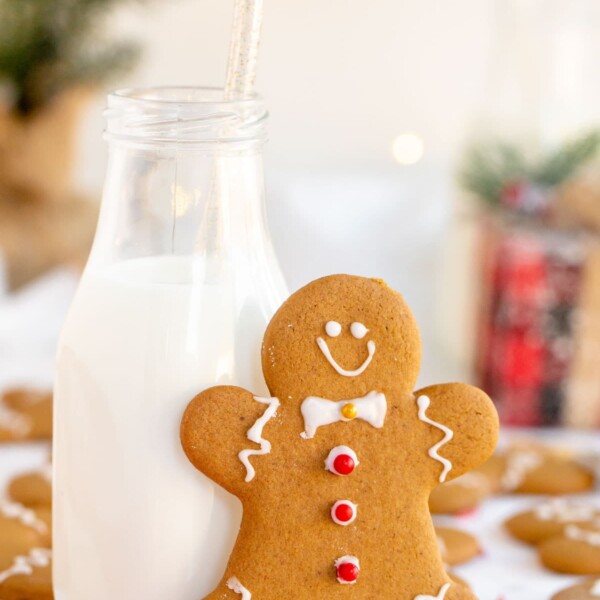 gingerbread man leaning on a glass of milk