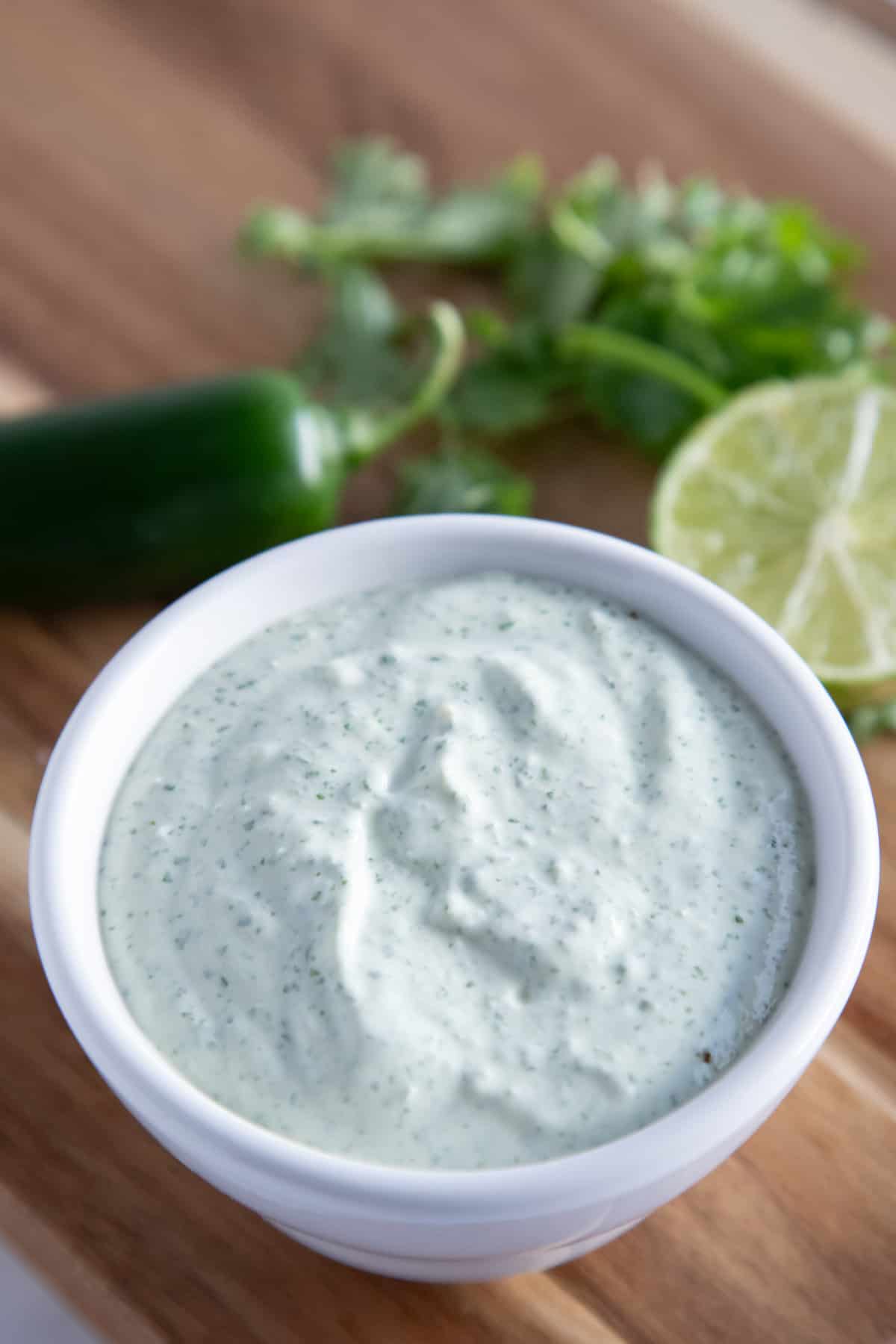 jalapeno ranch in a bowl with cilantro and lime.