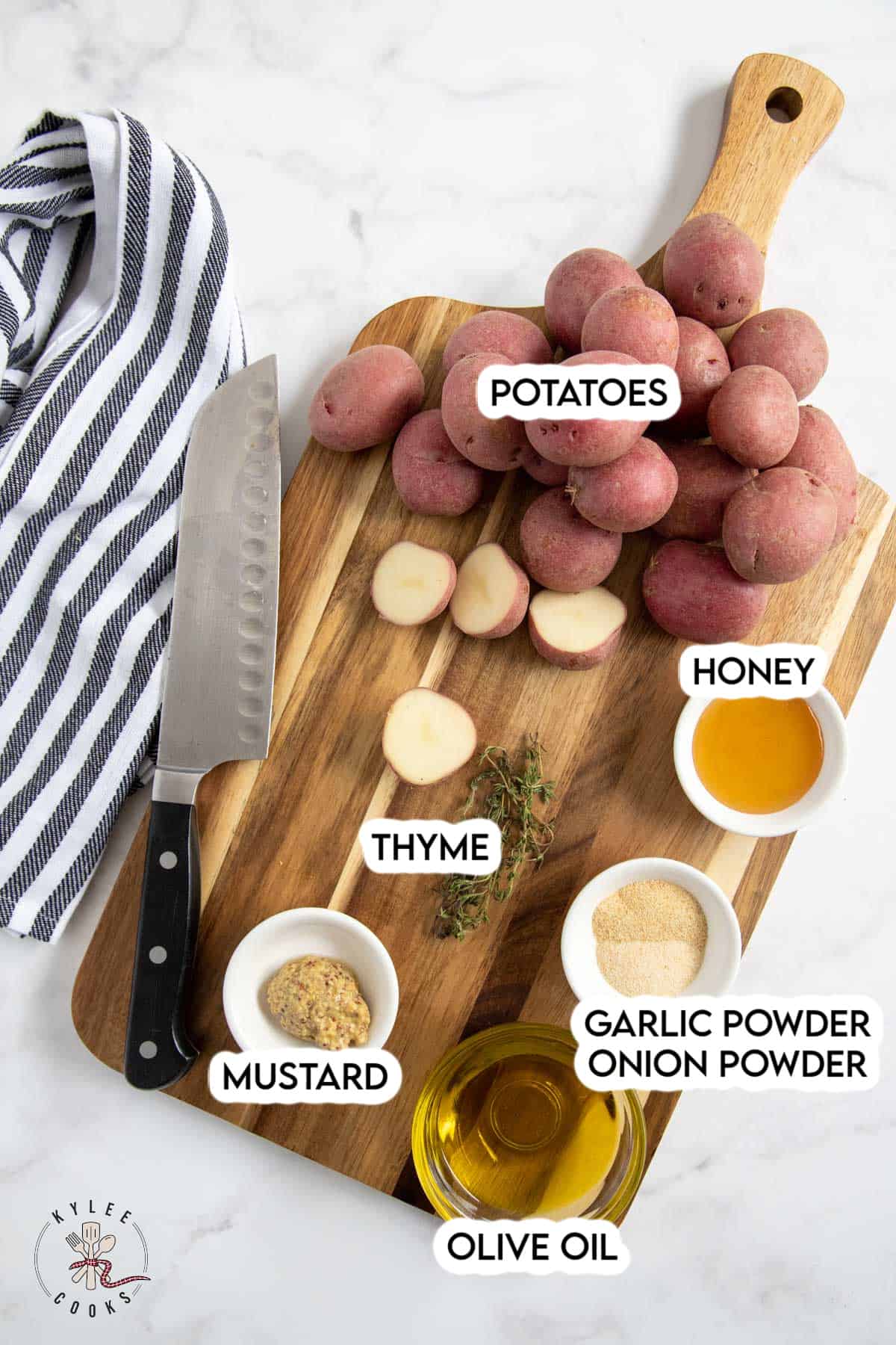 ingredients to roast potatoes laid out on a white board