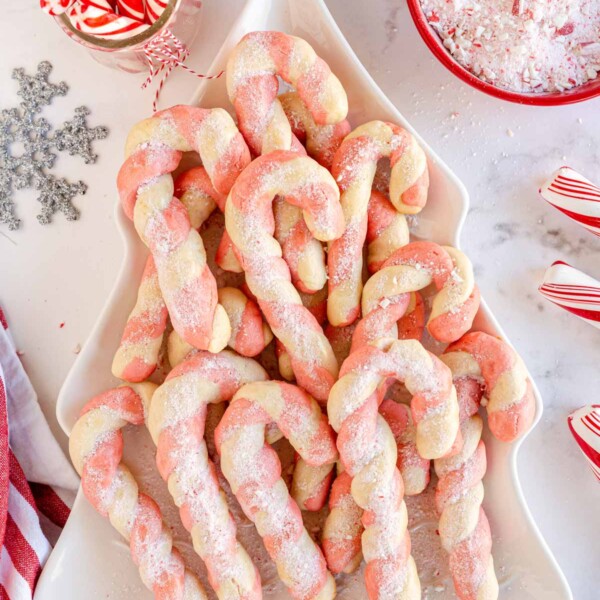 candy cane cookies on a white tree shaped plate