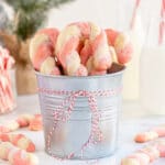 candy cane cookies in a tin with red ribbon