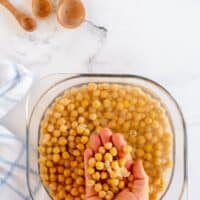hand in a bowl of shelled chickpeas