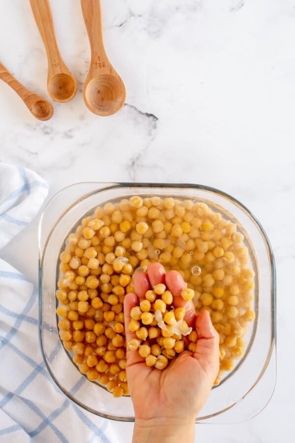 hand in a bowl of shelled chickpeas