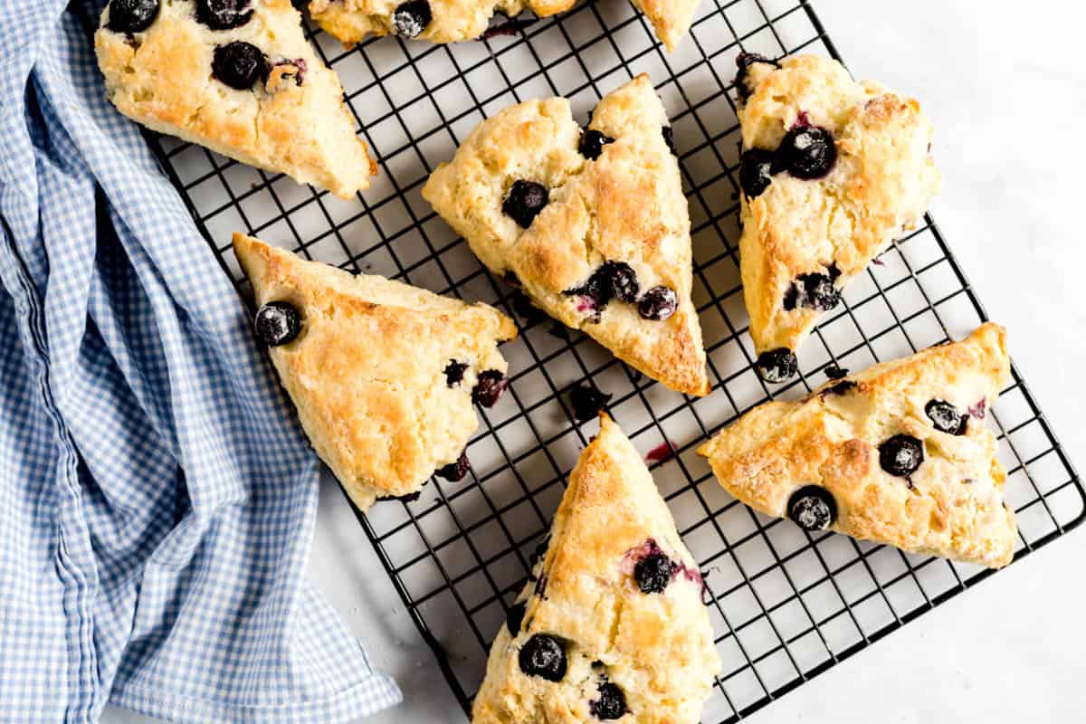 Blueberry scones on a baking rack with a blue napkin