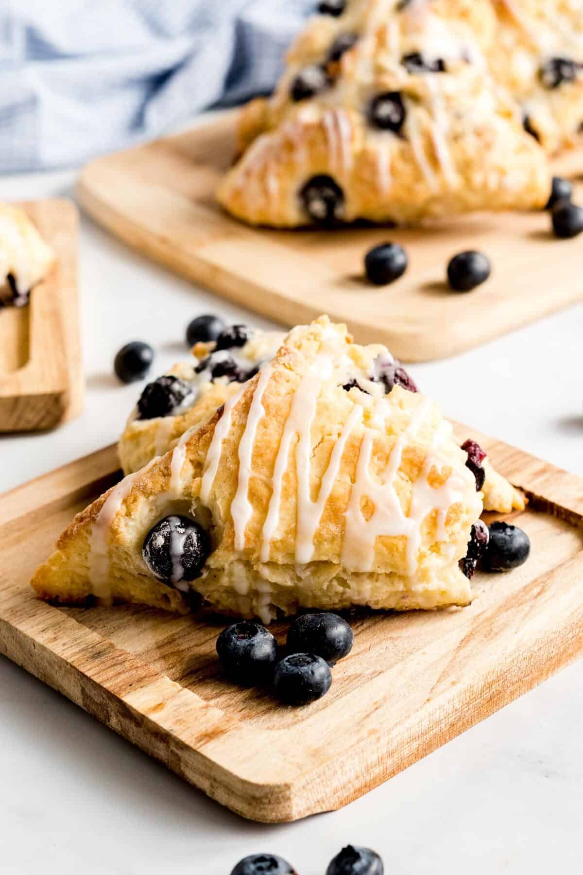 Blueberry scones with vanilla glaze on a wooden board