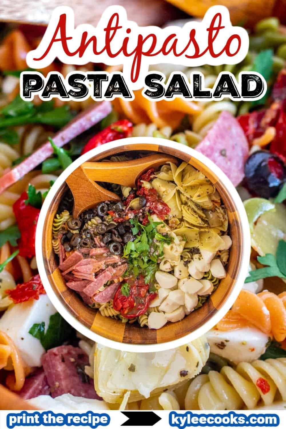 antipasto salad in a wooden bowl with spoons