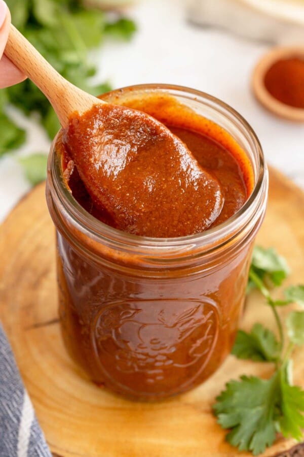 homemade enchilada sauce in a jar with a spoon