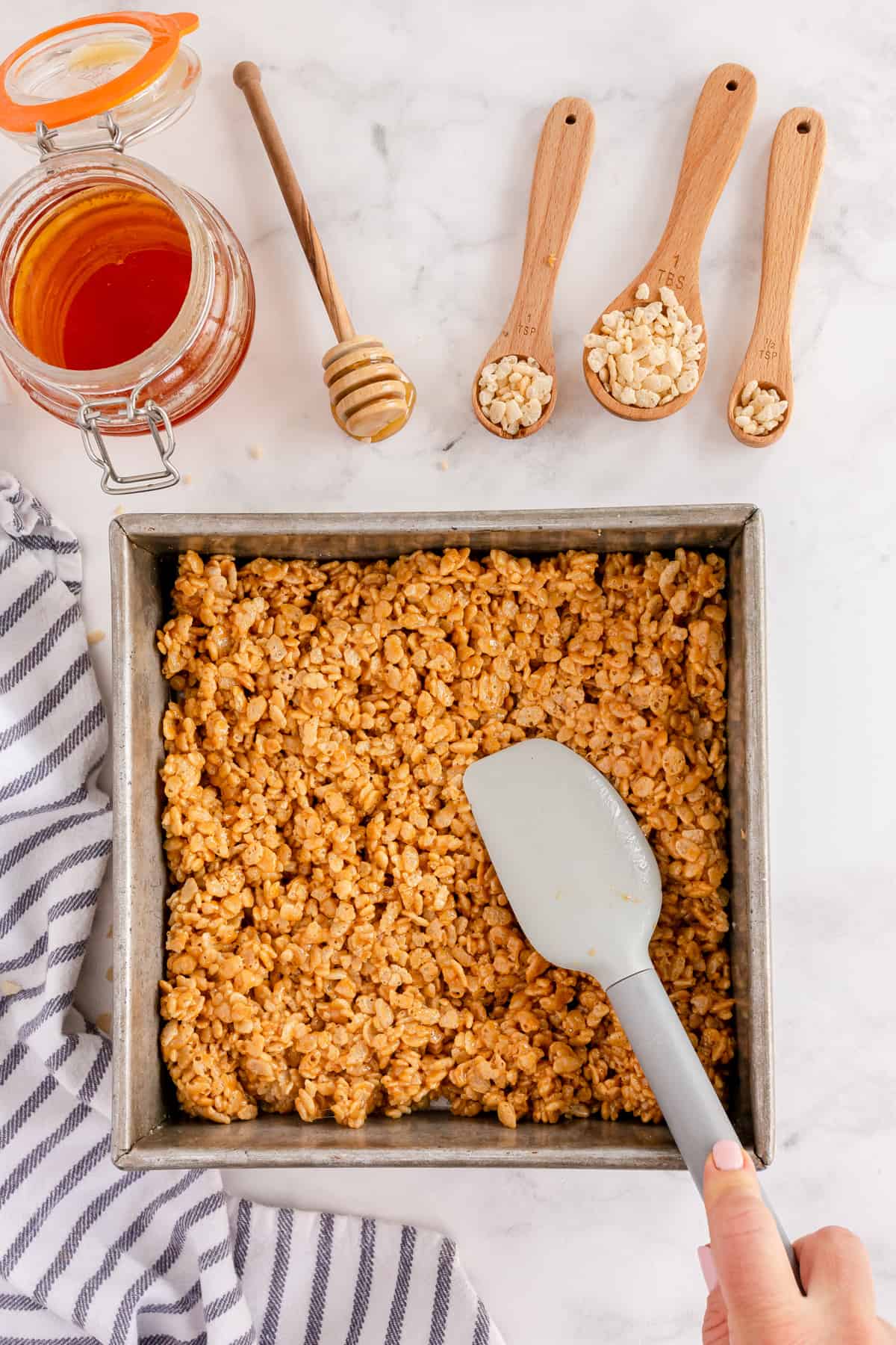 pressing rice krispie mixture into a pan