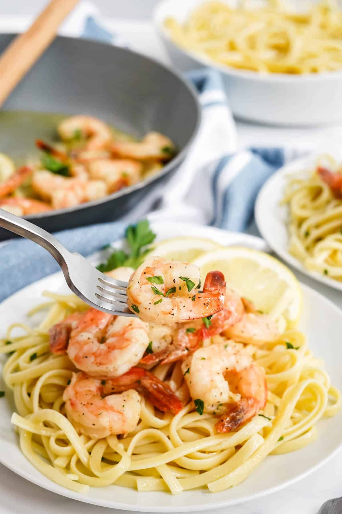 garlic butter shrimp on a white plate over spaghetti
