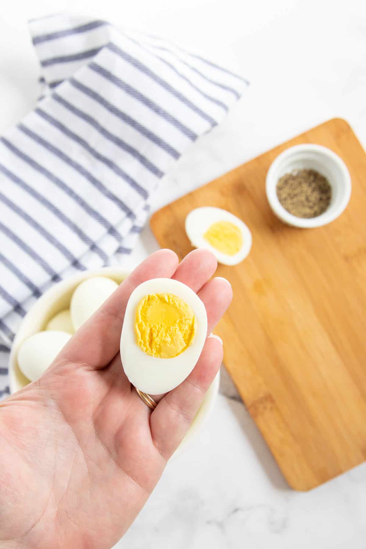 hand holding a boiled egg cut in half