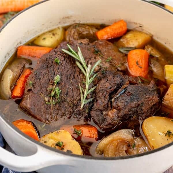 cooked pot roast in a white dutch oven