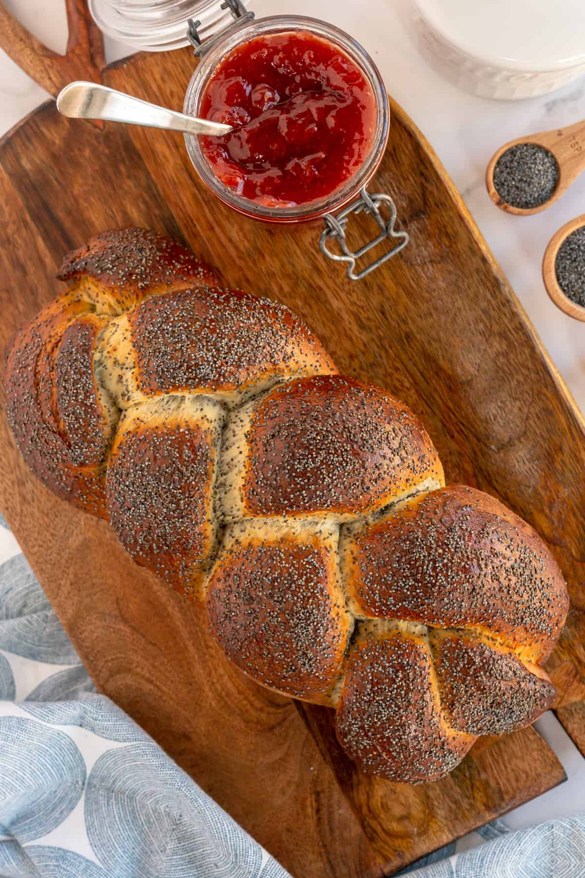 baked braided bread on a board with jam