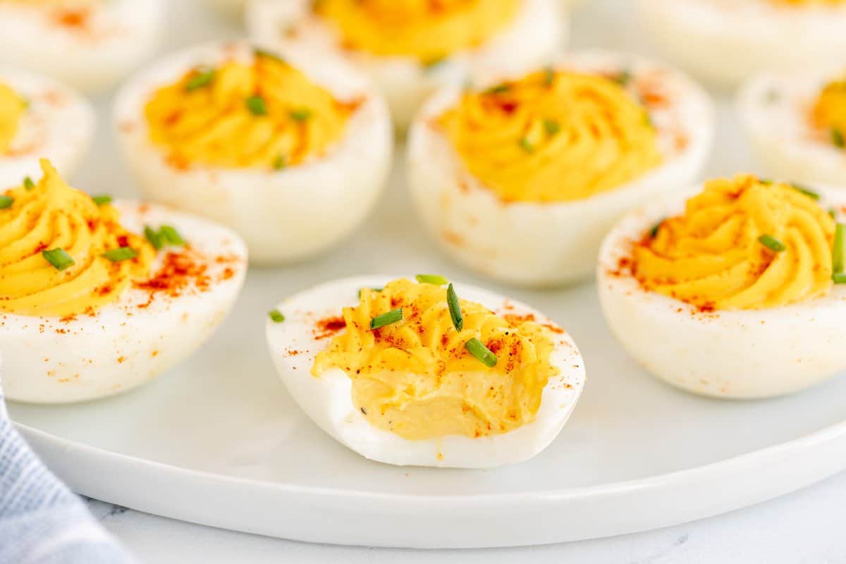 deviled eggs on a white plate with a bite taken out of one