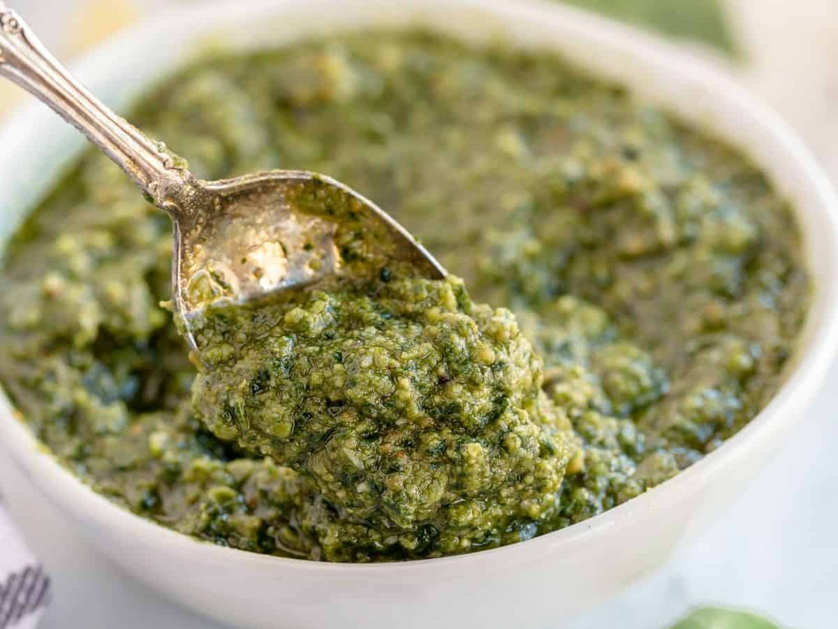 pesto in a white bowl with a spoon