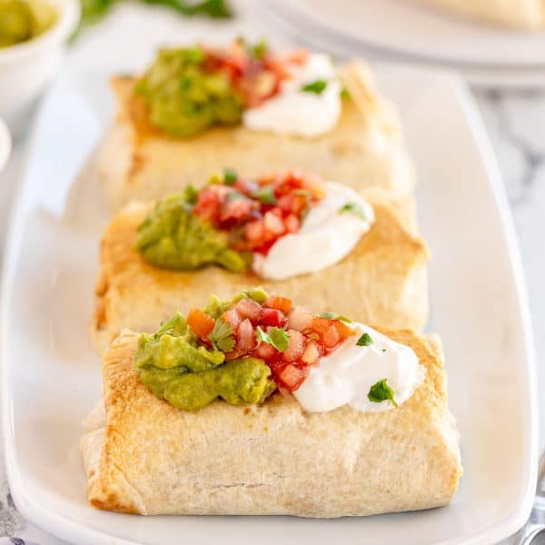 baked chicken chimichangas on a white plate.