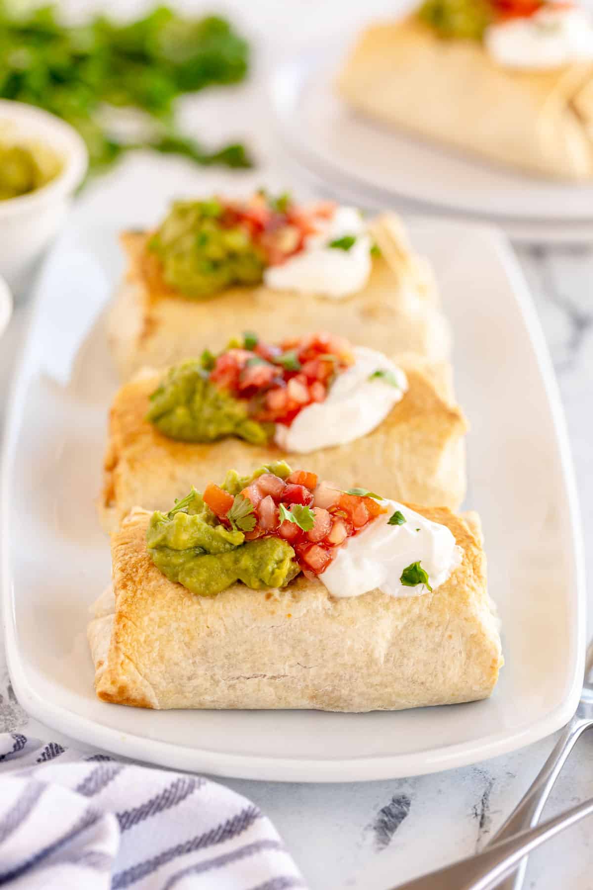 baked chicken chimichangas on a  white plate.